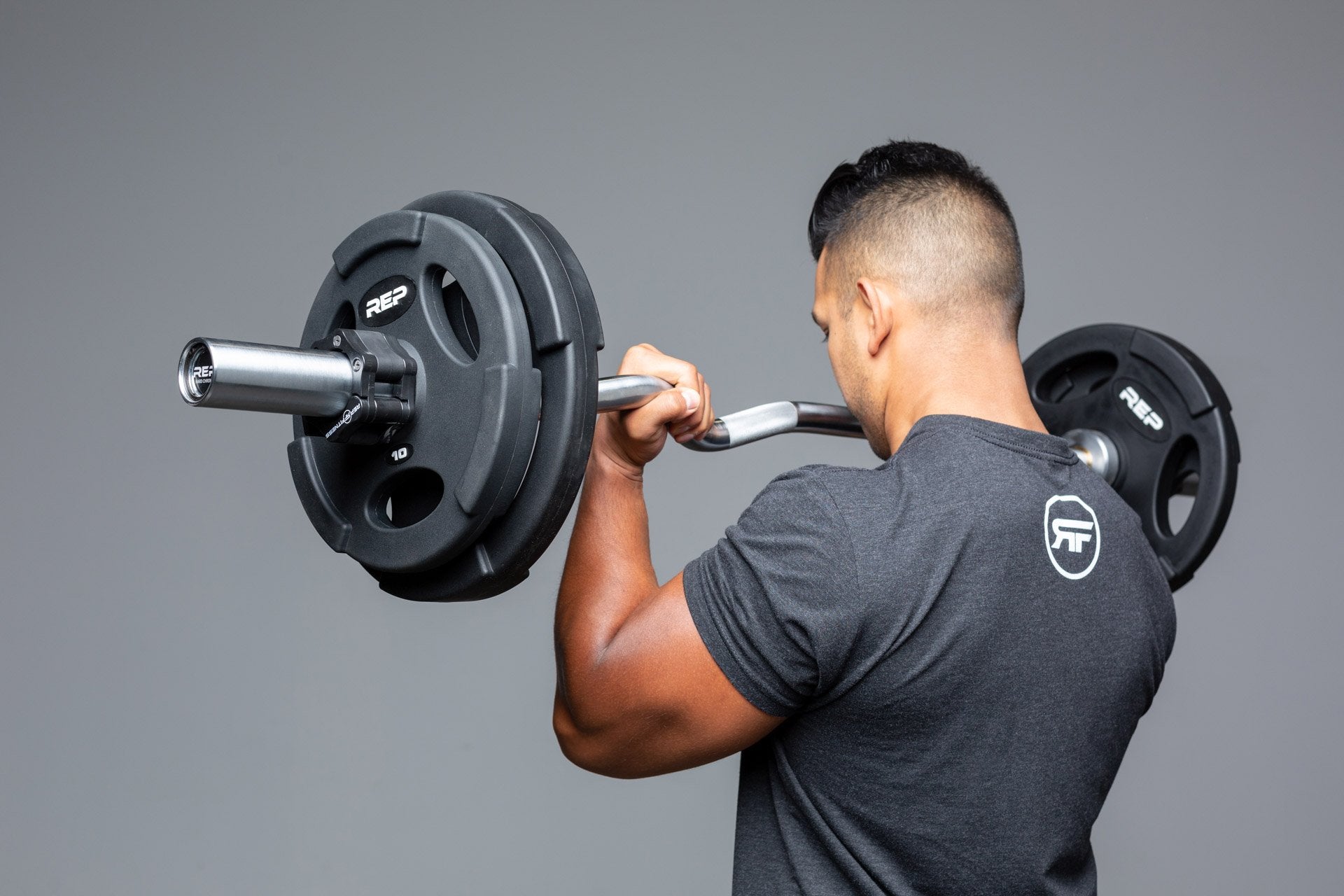 Lifter using loaded curl bar for bicep curls.