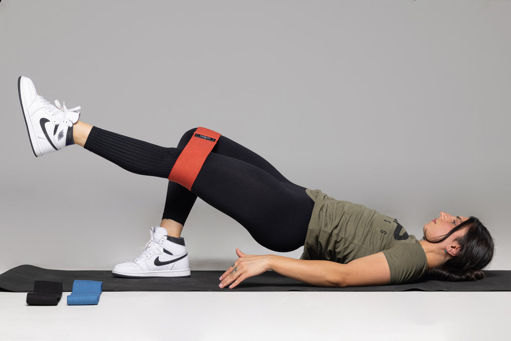 Lifter performing single leg hip thrusts using the red light resistance REP circle hip band.