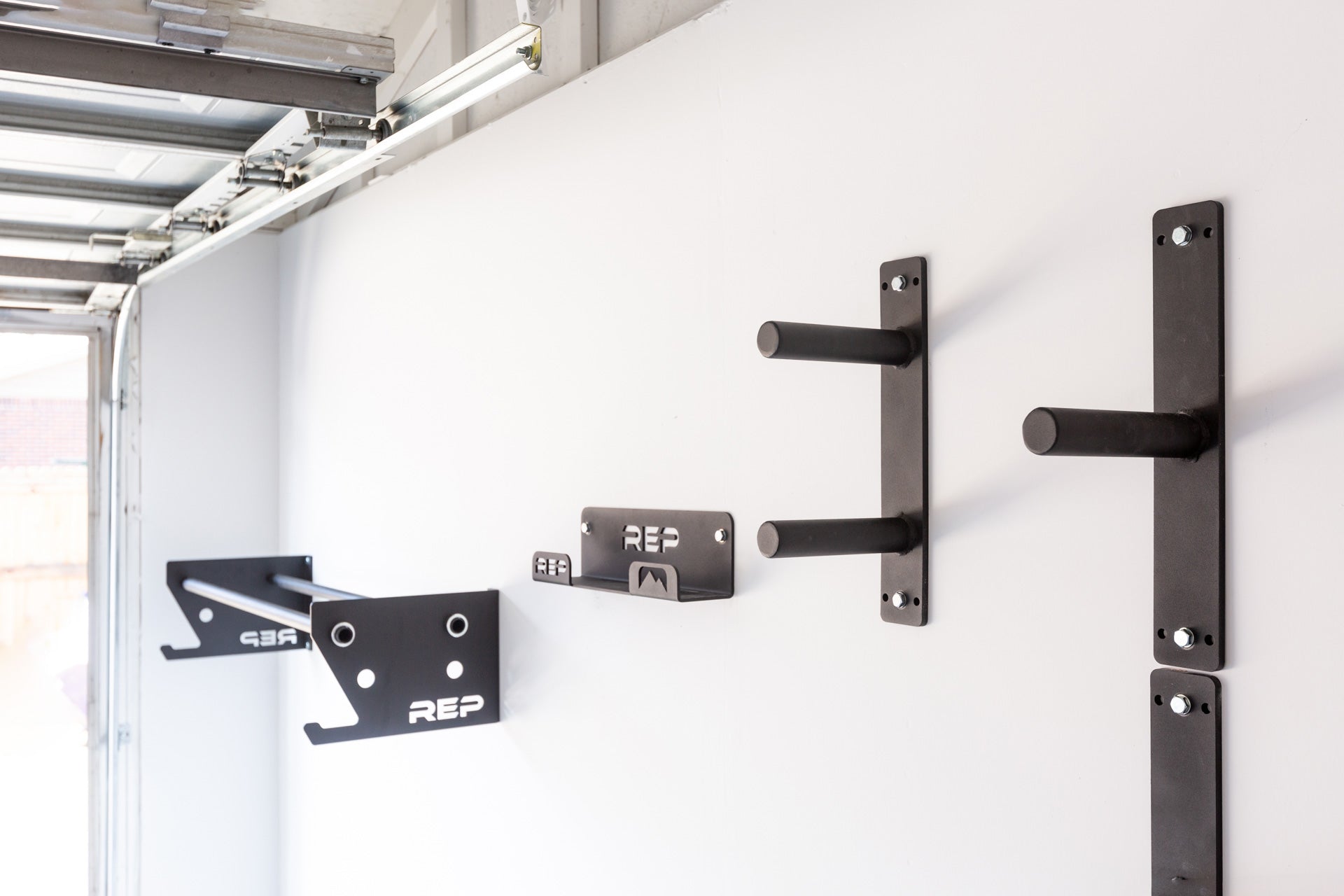 A garage gym showcasing a variety of REP space-saving wall storage including the single and double Wall Mounted Plate Storage.