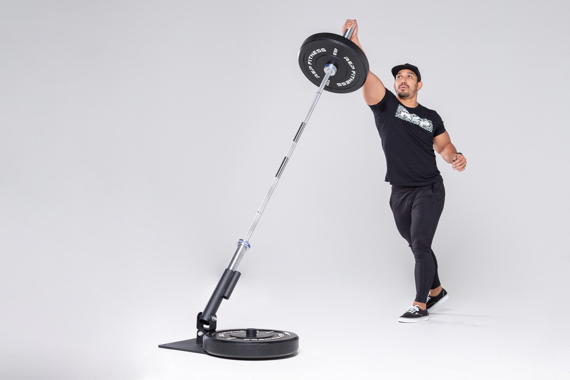 Lifter performing a single-arm overhead press with a loaded barbell in the REP Free Standing Landmine.