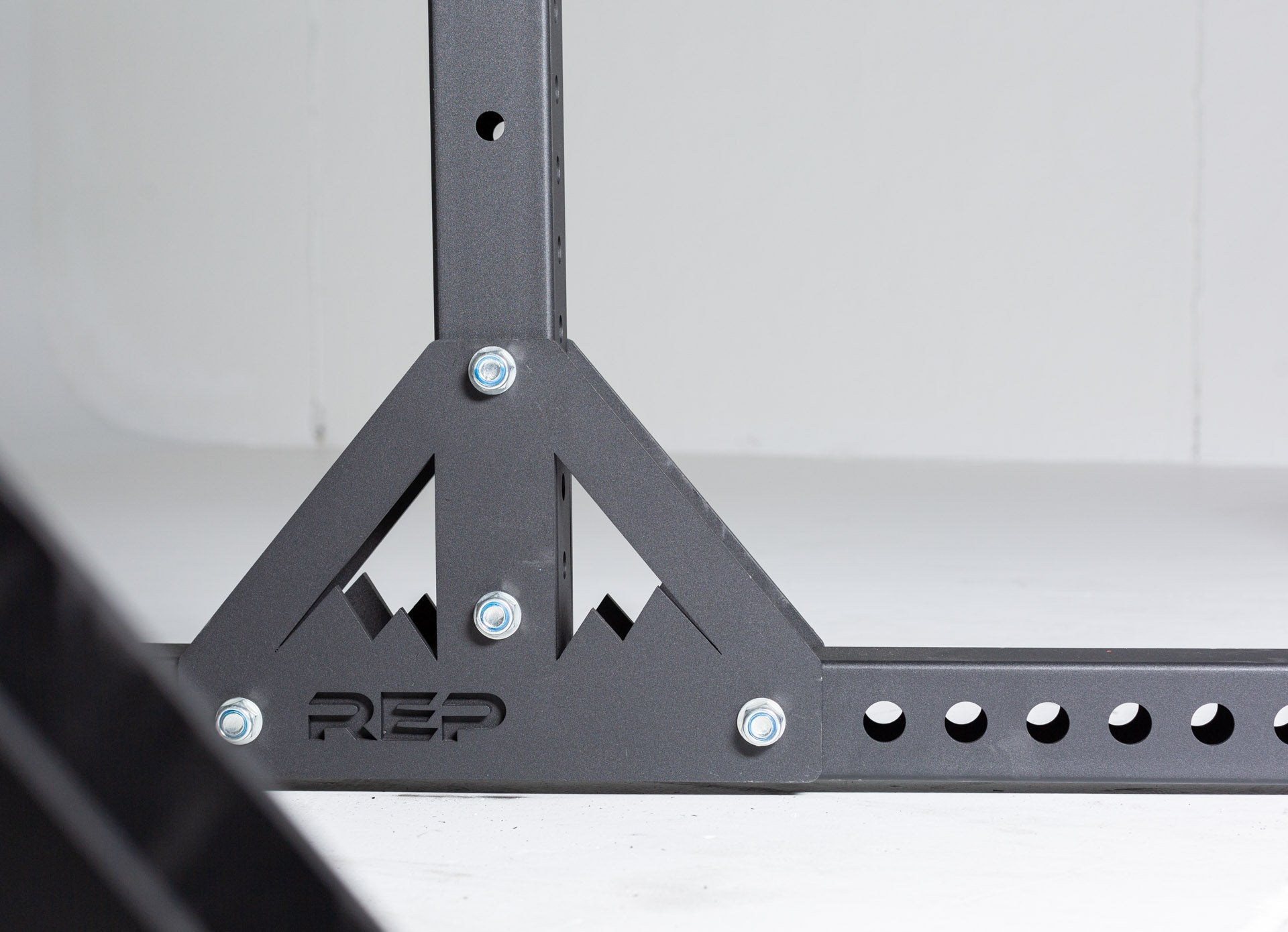SR-4000 Squat Rack Up Close of Triangular Reinforcements at the Base of Uprights With Mountain and Logo Detailing