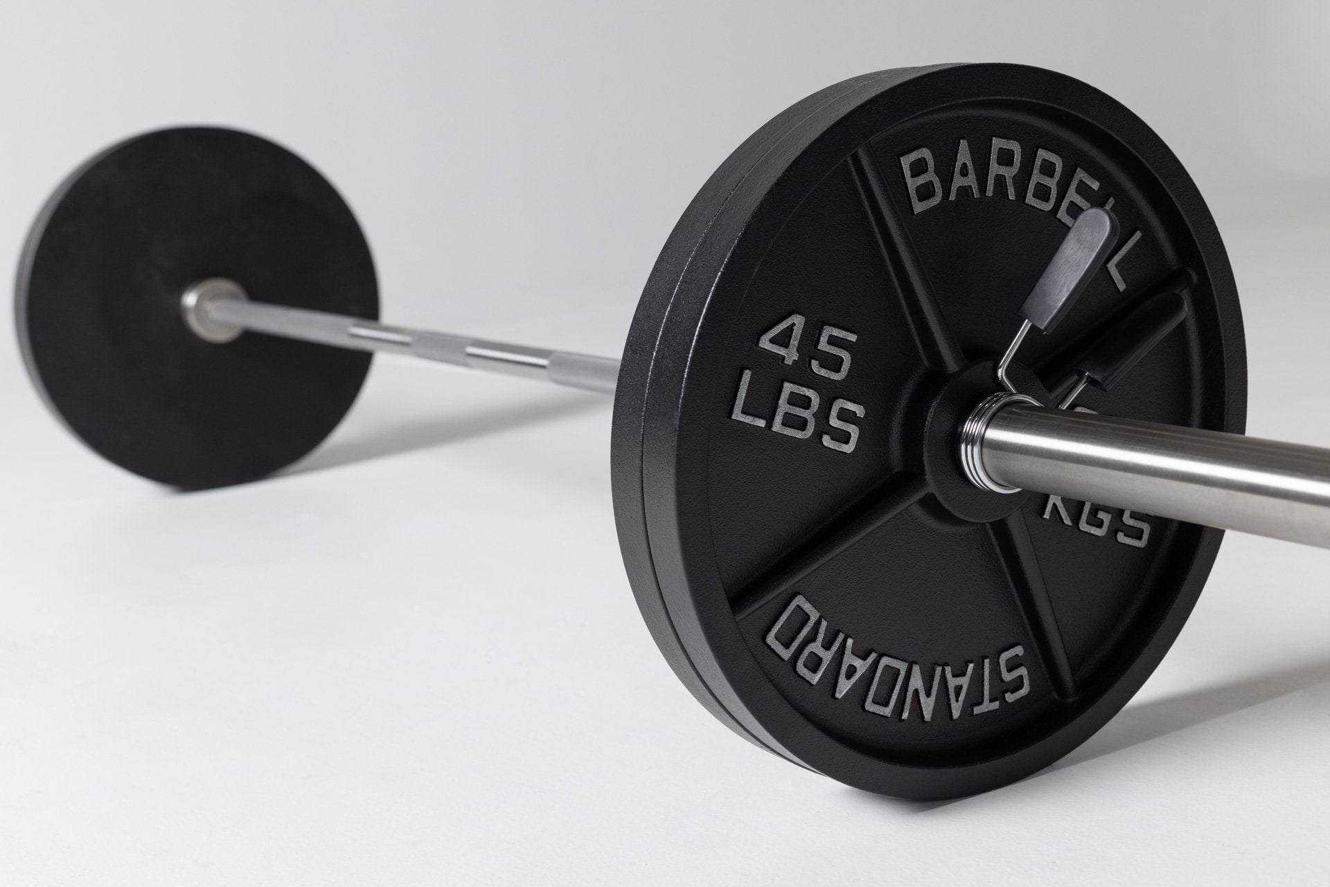 A barbell loaded with two pairs of 45lb Old School Iron Plates and secured with REP spring clips.